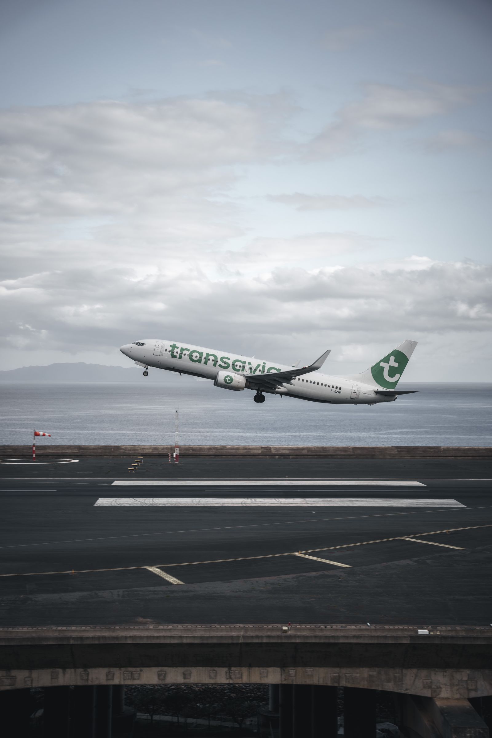 An aircraft taxiing toward a runway at dusk