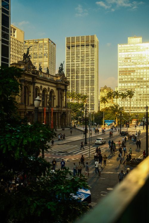 Free Vibrant city scene at sunset featuring Theatro Municipal and bustling street in São Paulo. Stock Photo