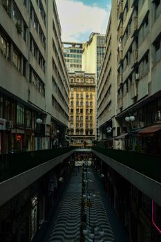 A narrow alley in São Paulo with historic architecture and vibrant street life.