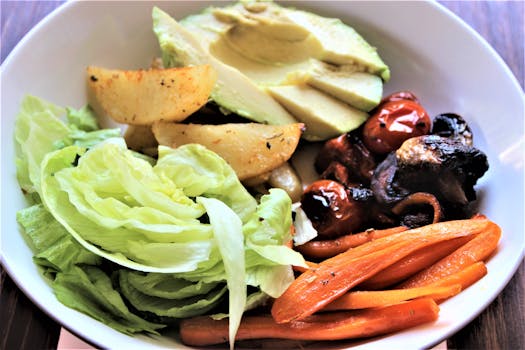 Delicious mixed vegetable salad featuring fresh lettuce, avocado, and roasted vegetables, perfect for a healthy diet.