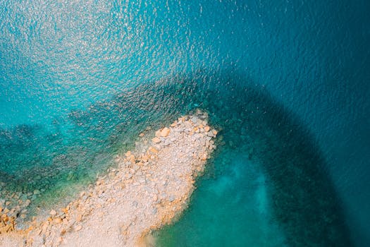 从空中俯瞰，岩石海岸线与绿松石水域勾勒出突出的热带海景