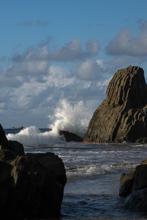 Free Powerful ocean waves crash against rugged boulders on the scenic coast of Pernambuco, Brazil. Stock Photo