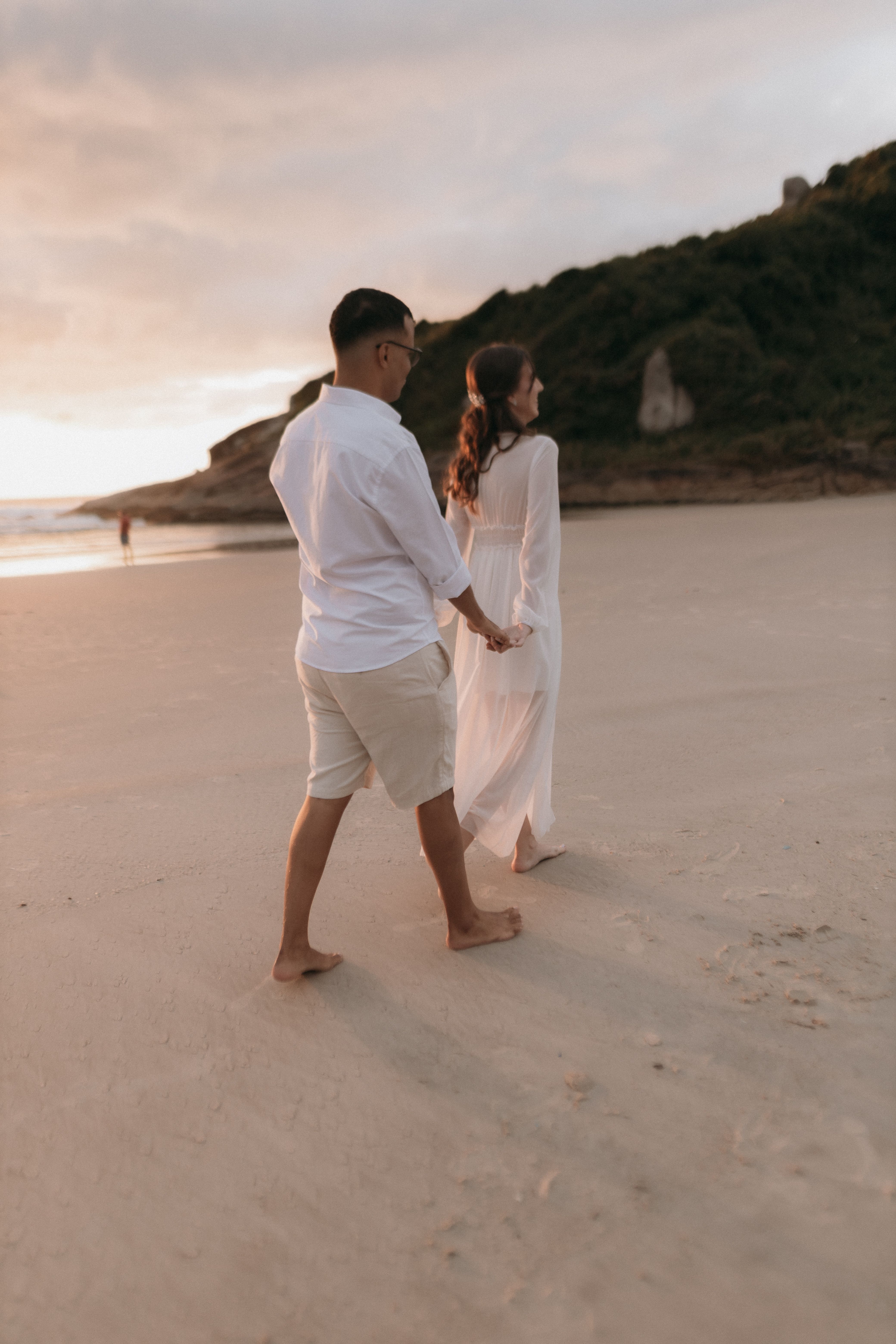 Couple walking barefoot on a sunset beach — photo by Alexander Mass on Pexels