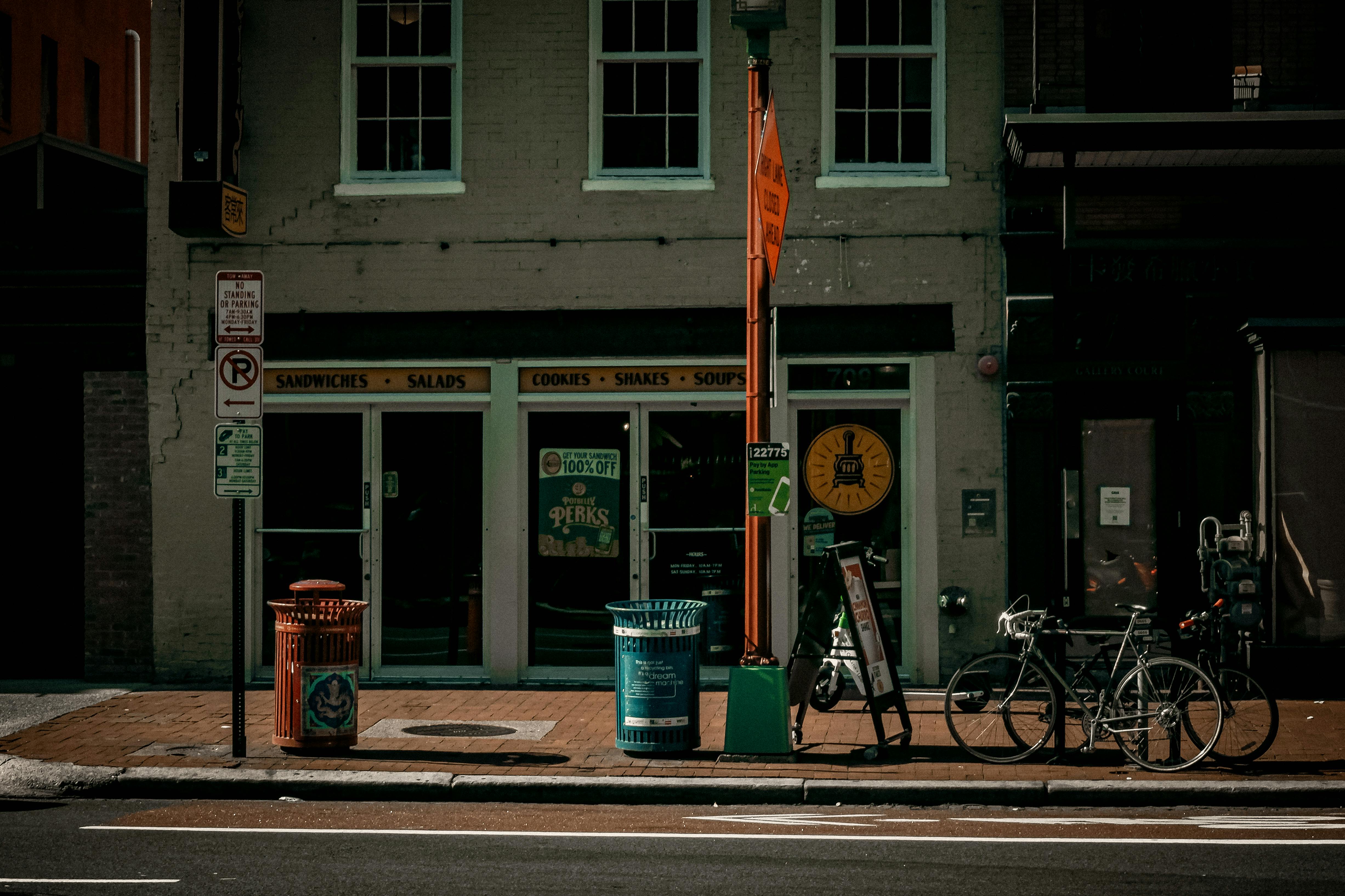 Gratis Vista de la fachada de una cafetería en Washington, D. C. Incluye bicicletas y letreros, ideal para representar el estilo de vida urbano. Foto de stock
