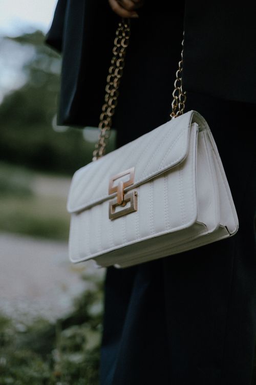 Free Stylish white handbag with gold chain details, perfect for any occasion. Stock Photo