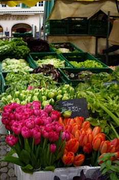 Colorful market stall featuring fresh vegetables and tulips on display.