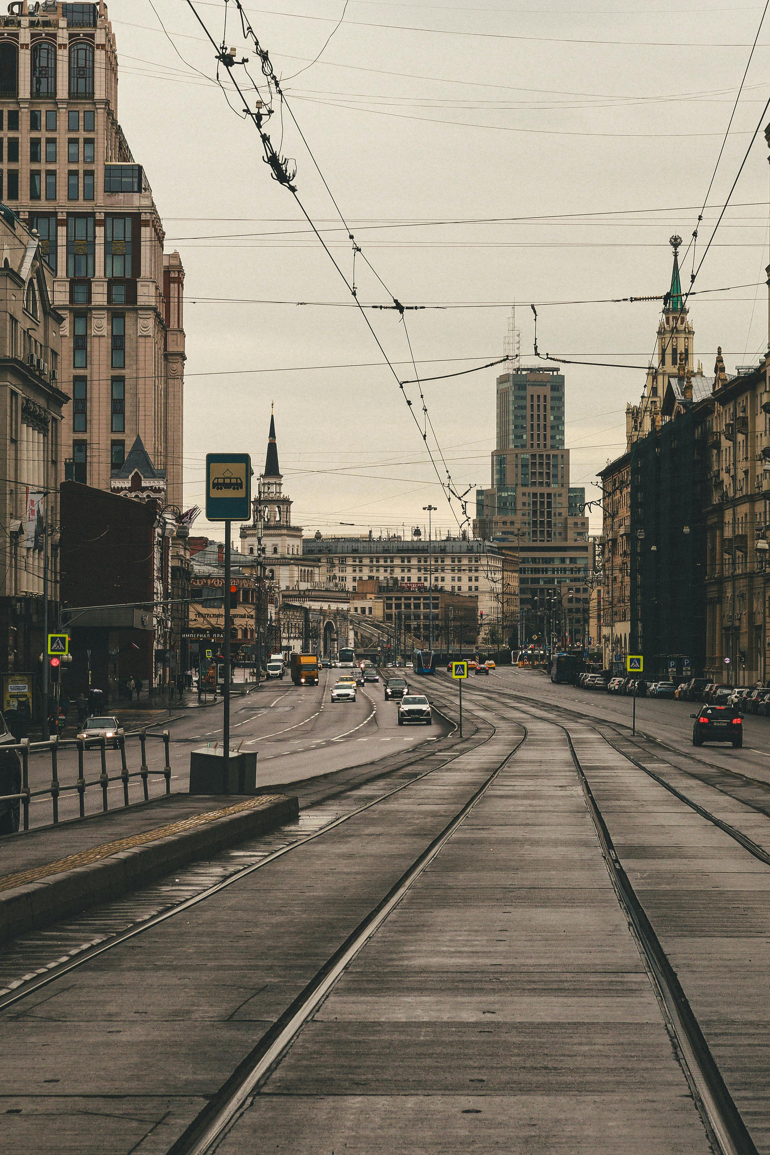 City street in Moscow featuring trams and historic architecture with cloudy sky.