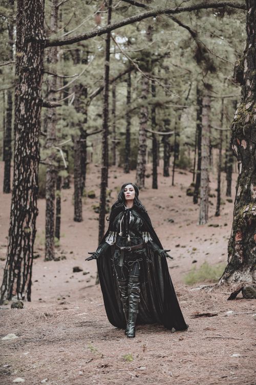Free A captivating woman in cosplay attire wanders through a tranquil pine forest. Stock Photo