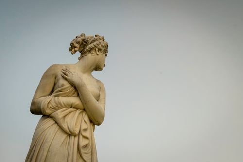 Free A marble statue of a serene figure gazes towards the sky, symbolizing grace and history. Stock Photo