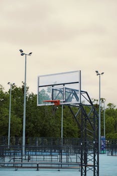 A minimalist outdoor basketball court in Kyiv with chain net and metal hoop.