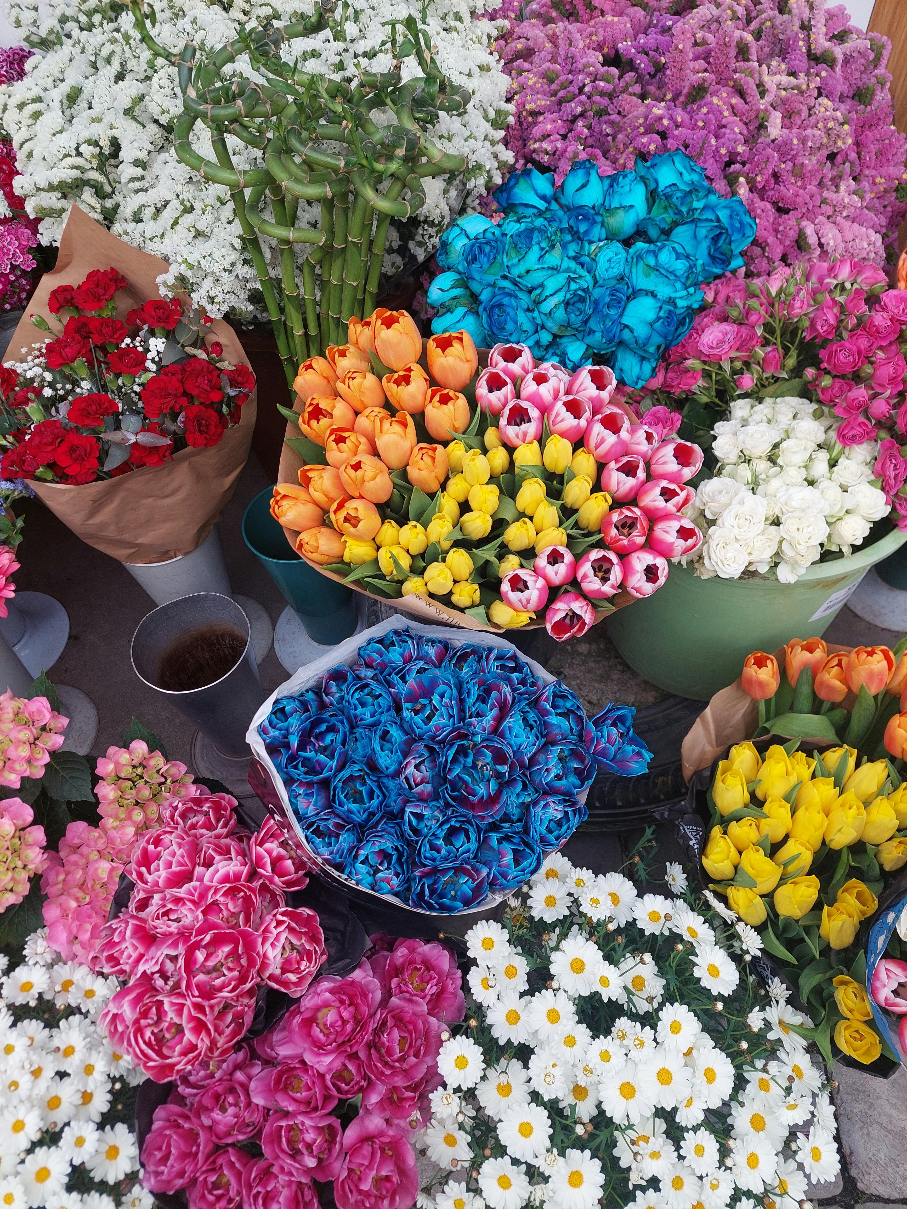[ColoSach]-vibrant-assortment-of-flowers,-including-tulips,-at-a-market-stall,-showcasing-a-vivid-color-palette.