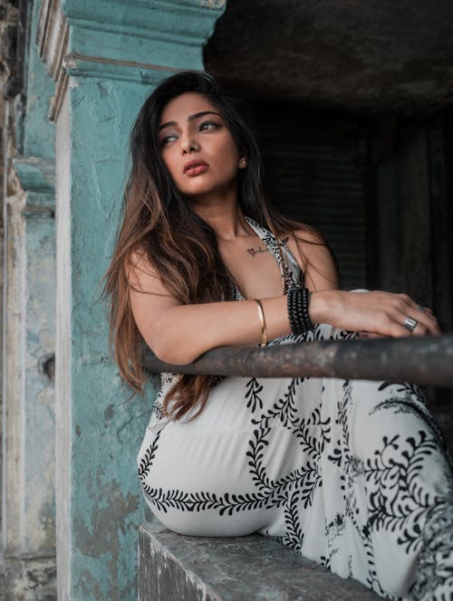 Shallow Focus Photo of Woman in White and Black Floral Sleeveless Dress