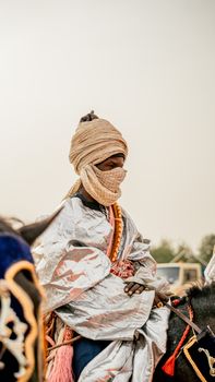 Man dressed in traditional Nigerian attire participates in a ceremonial horse ride in KT, Nigeria.