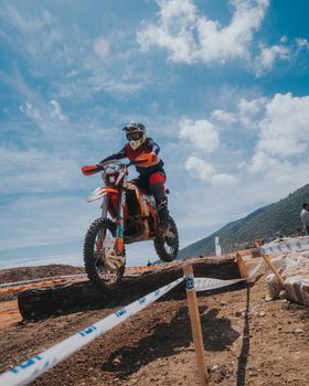 Dynamic shot of a motocross rider navigating an obstacle during a race.