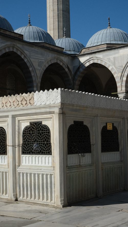 Free Beautiful stone architecture and blue domes of a historic mosque under clear skies. Stock Photo