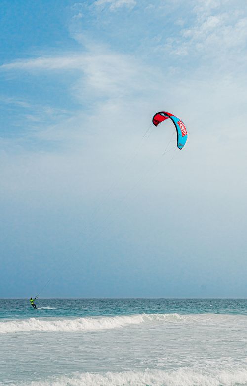 Free A kite surfer enjoying the ocean waves on a sunny day, showcasing outdoor adventure and water sports. Stock Photo