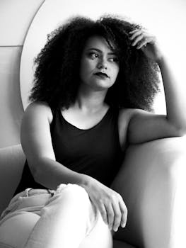 Black and white portrait of a thoughtful woman sitting in an armchair.