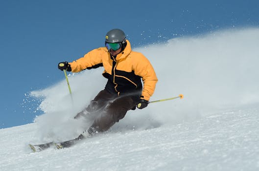 A focused skier wearing a bright jacket expertly navigating a snowy slope under clear skies