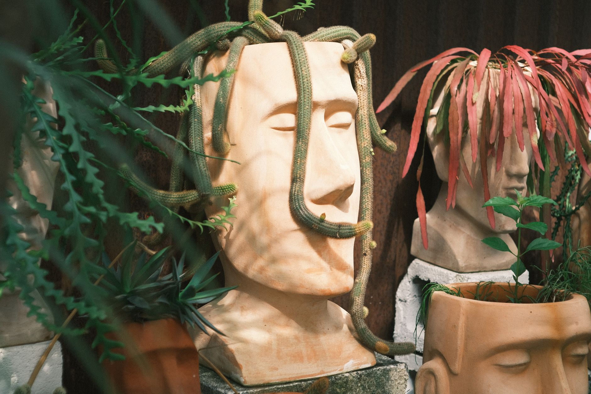 Unique terracotta plant sculptures with succulents create an artistic garden atmosphere.