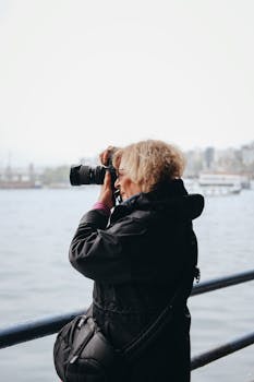 A photographer taking pictures by the waterfront in Istanbul, highlighting urban exploration and creativity.