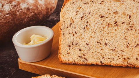 Delicious freshly baked artisan bread with butter spread, perfect for a healthy breakfast.