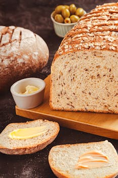 Delicious freshly baked artisan bread with butter spread, perfect for a healthy breakfast.