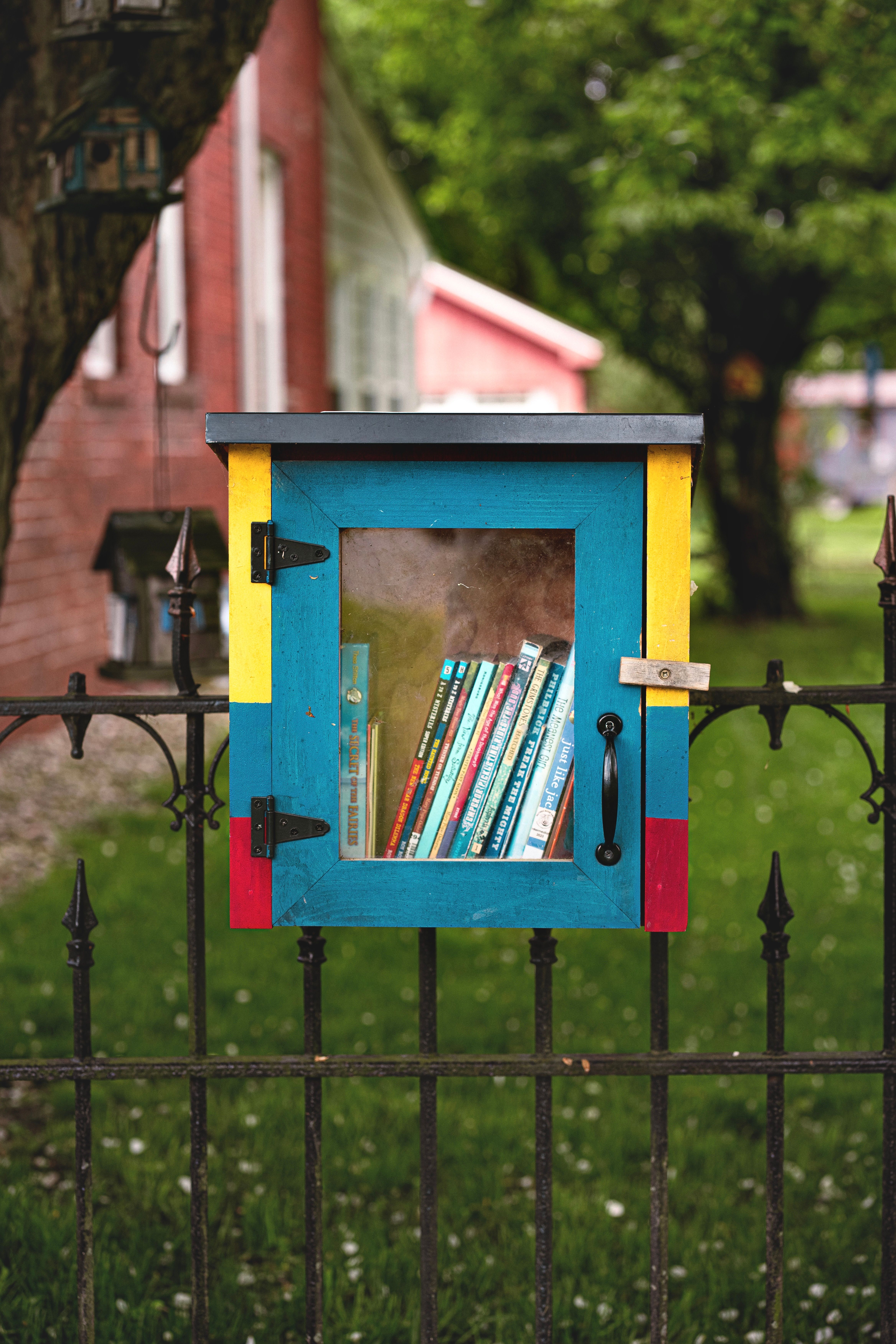 Colorful Outdoor Little Free Library on Iron Fence · Free Stock Photo