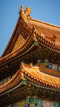 Close-up of a traditional Chinese temple roof, showcasing intricate design elements under a clear blue sky.