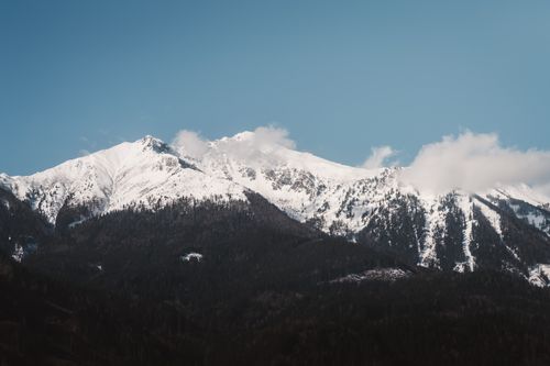 Free A scenic view of snow-covered mountain peaks under a clear blue sky, capturing winter's beauty. Stock Photo