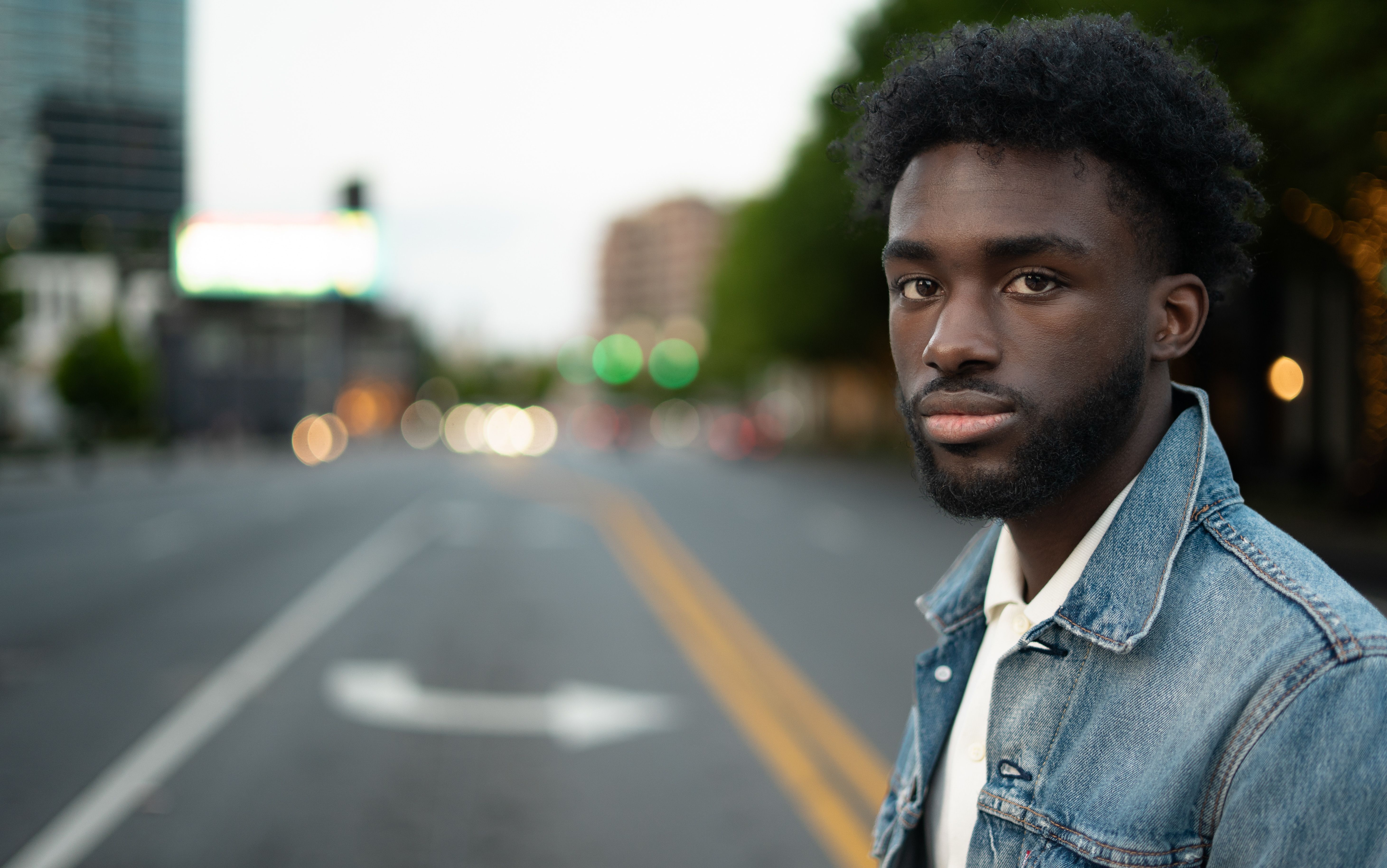 Man in Denim Jacket on Urban Street at Dusk · Free Stock Photo