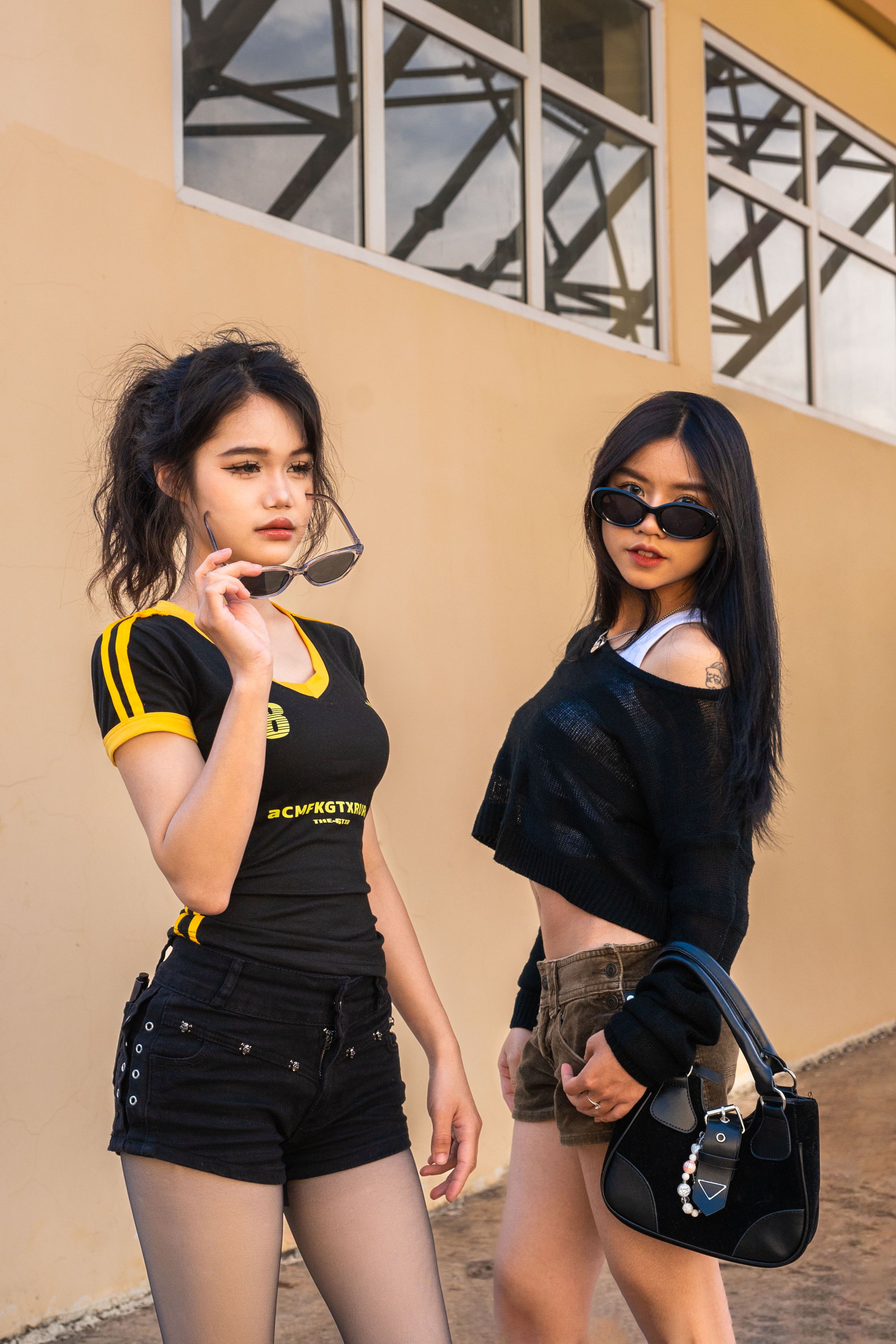 Two Stylish Women Posing Outdoors in Sunglasses · Free Stock Photo