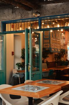Cozy café in Dubai featuring rustic wooden tables, vibrant colors, and warm lighting.