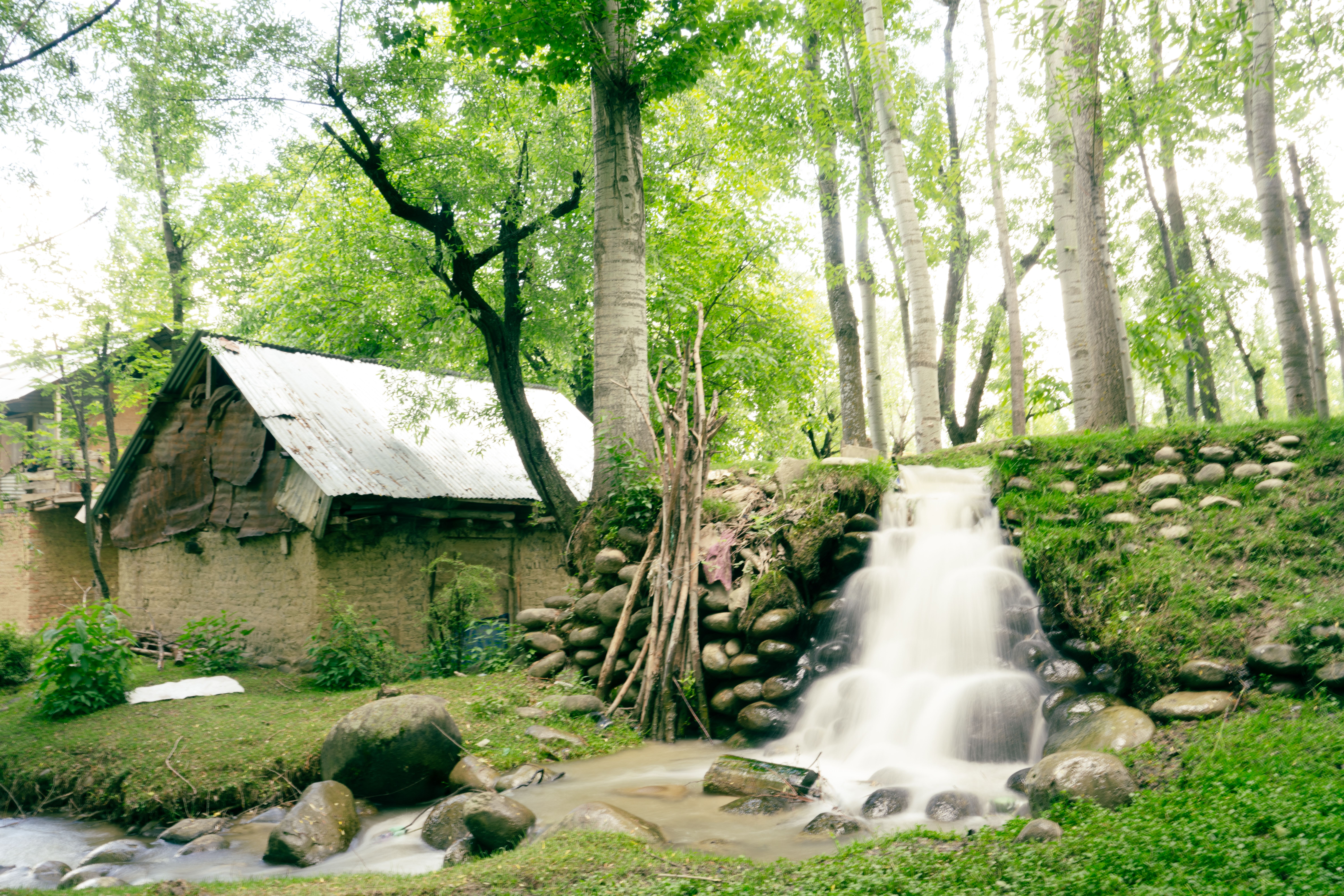 Serene Waterfall beside Rustic Houses in Badgam · Free Stock Photo