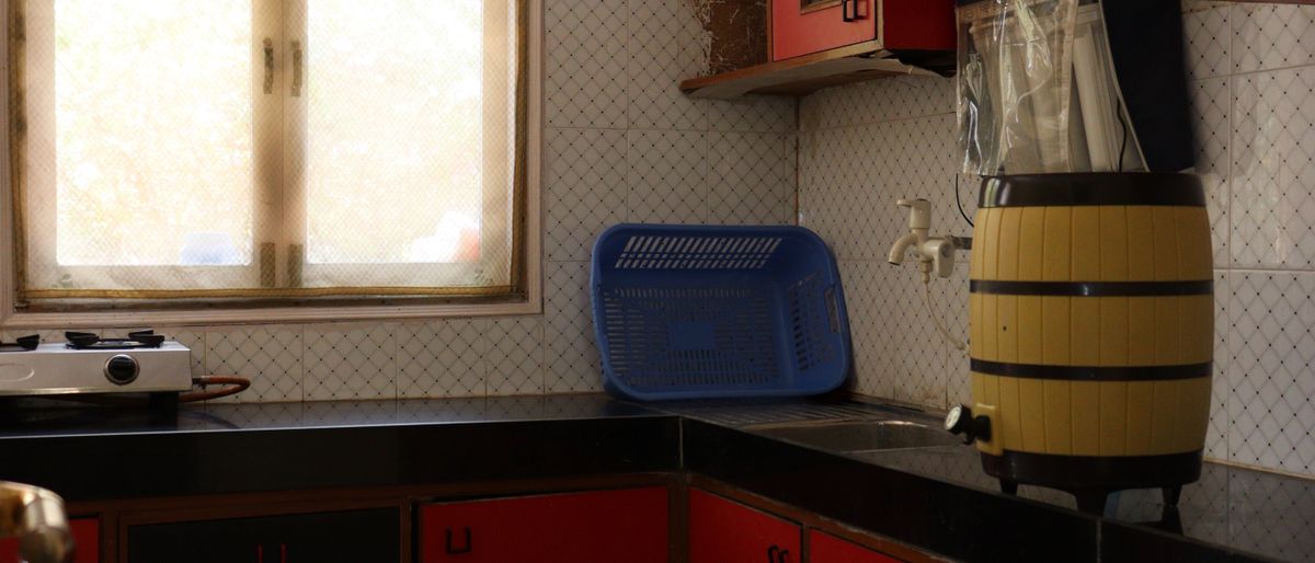 Person weighing food on kitchen scale indian kitchen