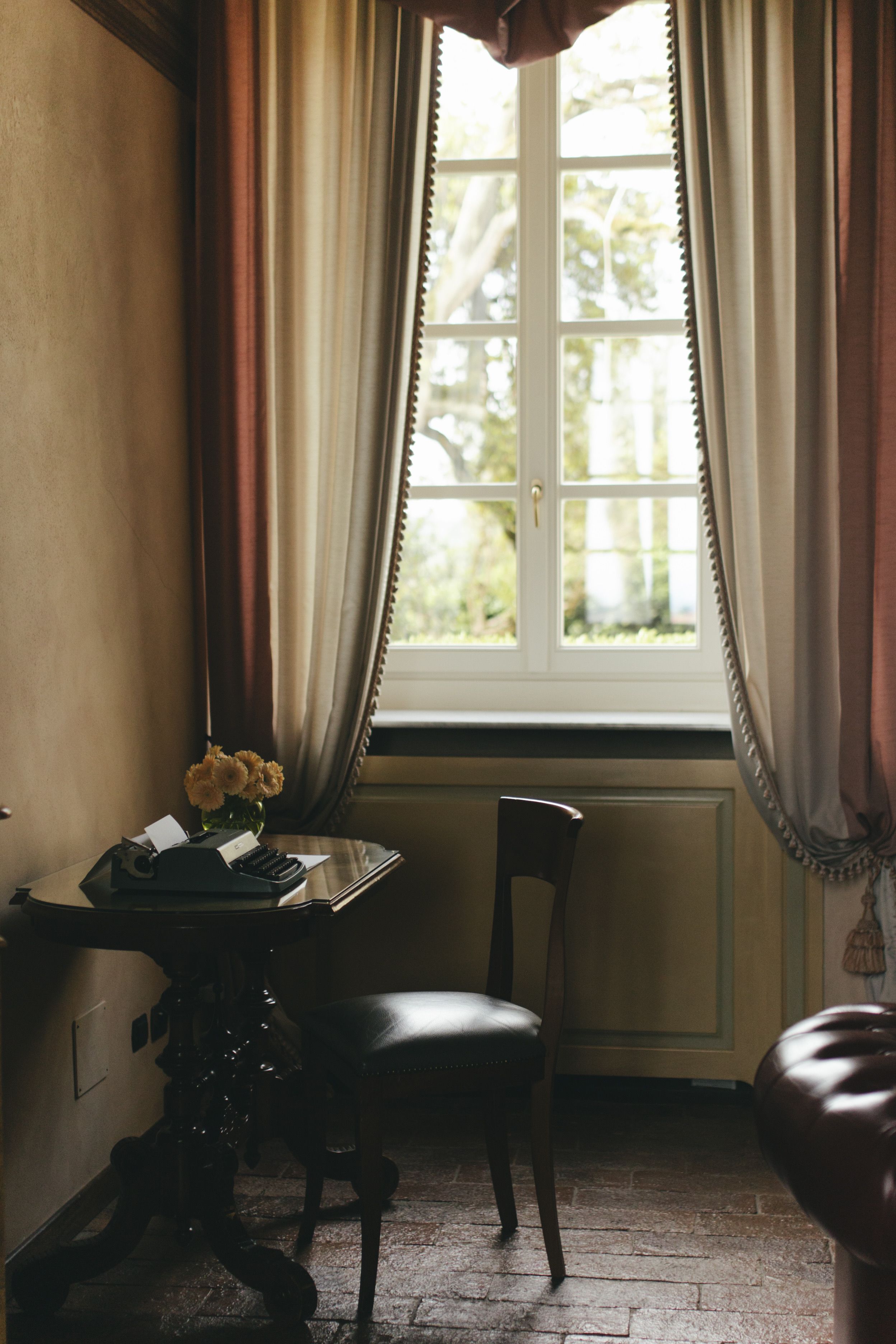 A cozy vintage corner with a window view in an elegant Italian interior room.