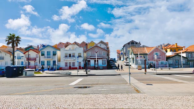Vibrant striped houses in Costa Nova, Aveiro, with clear blue skies. Iconic Portuguese seaside architecture.