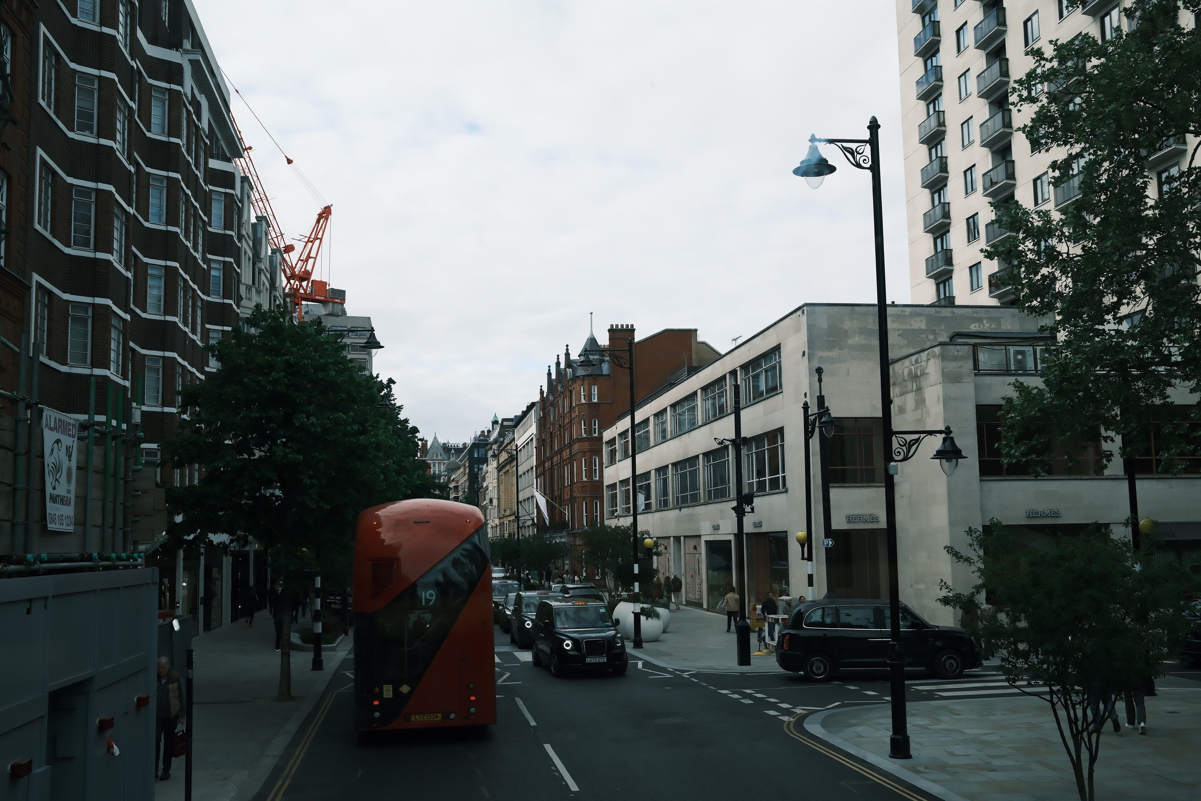 Urban street in London featuring a classic red double-decker bus and city architecture.