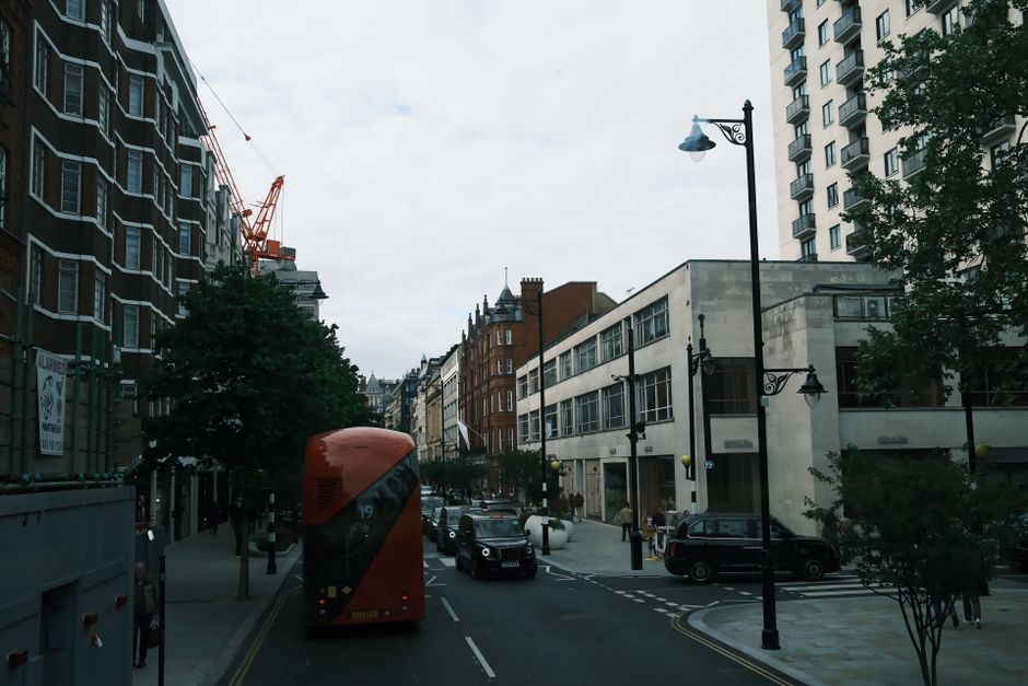 Urban street in London featuring a classic red double-decker bus and city architecture.