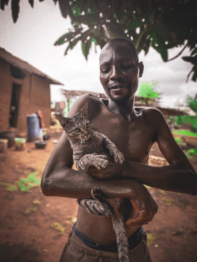 Man Carrying Tabby Cat