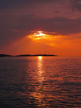 Beautiful sunset casting vibrant hues over the ocean, creating a serene and picturesque view.