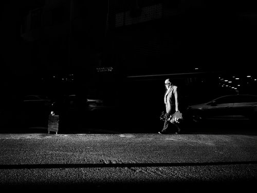 Free Dramatic black and white street photo of an adult man walking at night in Istanbul. Stock Photo