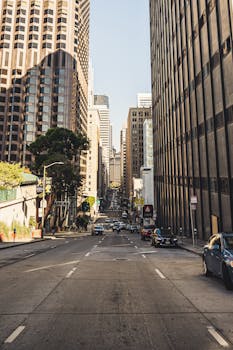 晴朗的天空下，繁华的城市街景中高楼林立，车水马龙