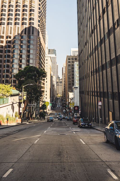Free A bustling city street view showing tall buildings and traffic under a clear sky. Stock Photo
