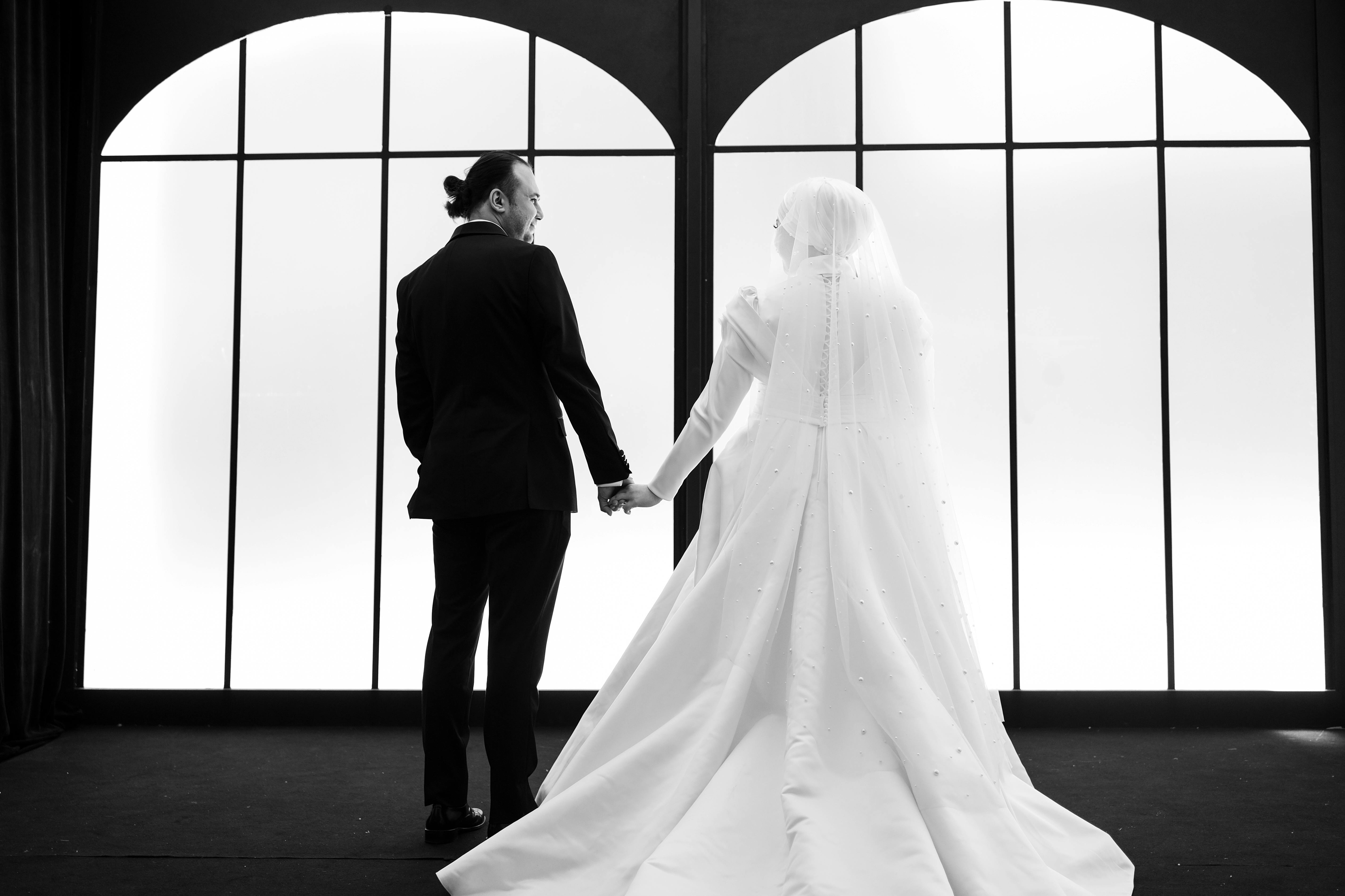 A couple holding hands in a captivating black and white wedding setting.