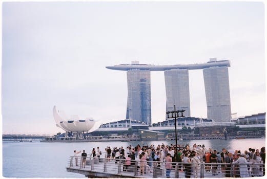 A crowd gathers at Marina Bay with the iconic Marina Bay Sands and ArtScience Museum in view.