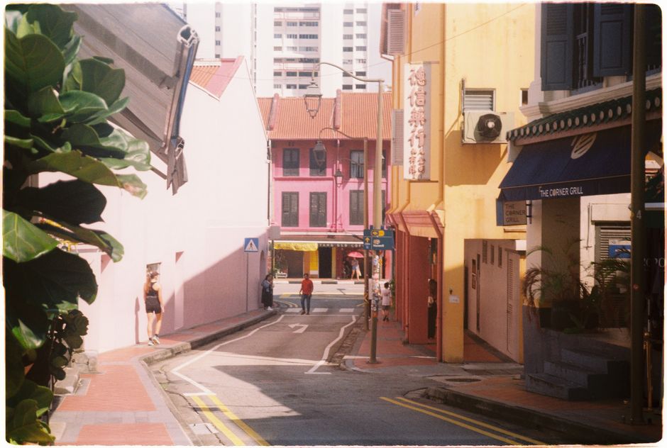 A vibrant, vintage street scene in Singapore showcasing colorful buildings and local life.