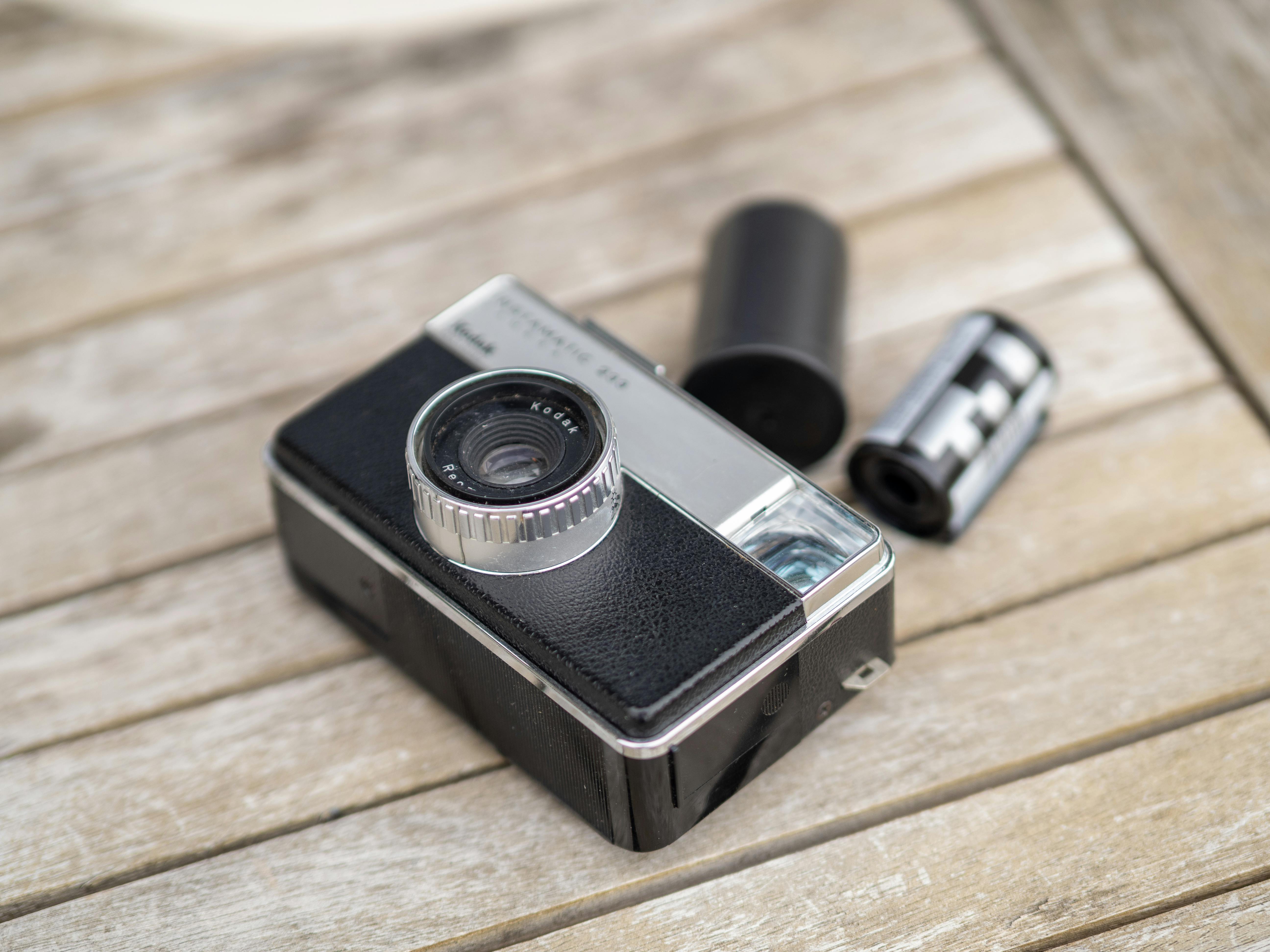 Retro analog camera with film roll on a wooden table. Perfect for vintage photography enthusiasts.