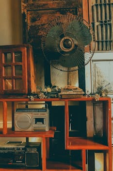 复古风格的越南客厅装饰，配有旧风扇、收音机和木制家具，充满怀旧气息