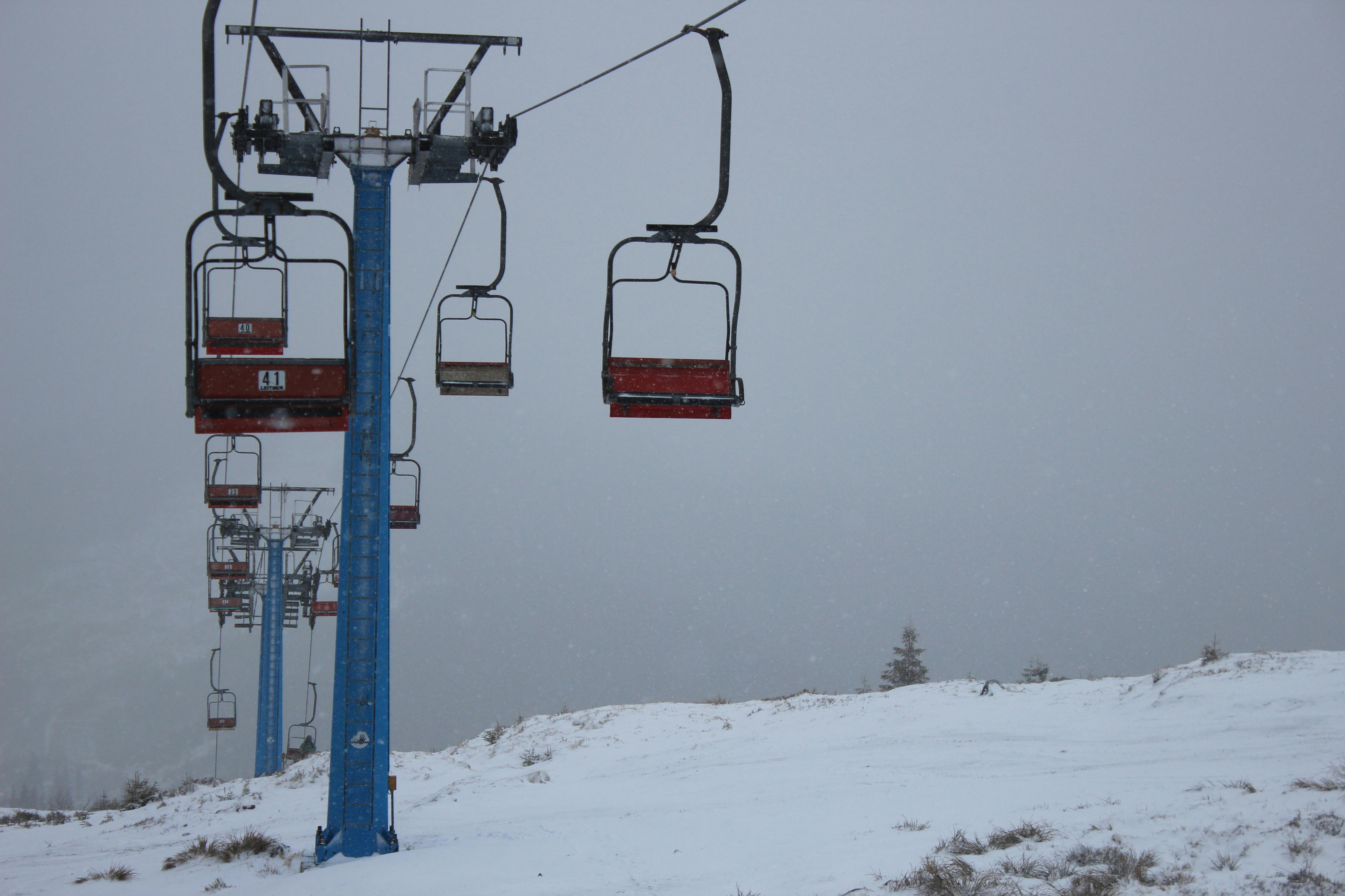 Snow-covered ski lift during a snowstorm in winter, perfect for skiing enthusiasts.
