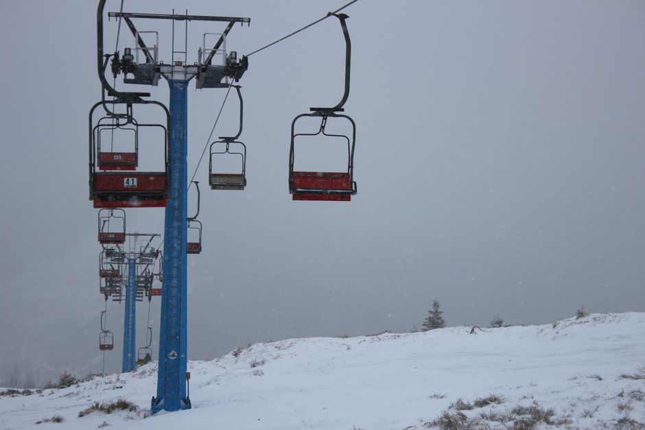 Snow-covered ski lift during a snowstorm in winter, perfect for skiing enthusiasts.